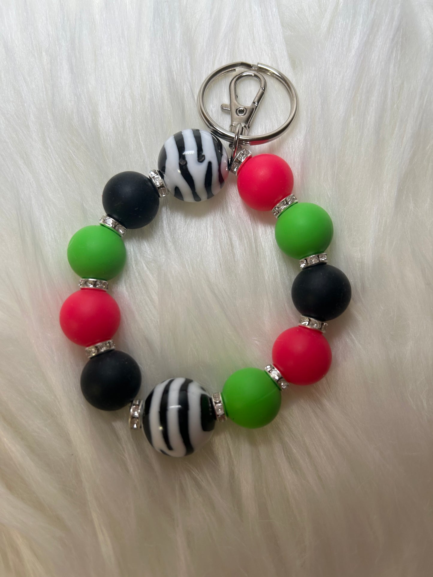 Green, pink, and black wristlet keychain