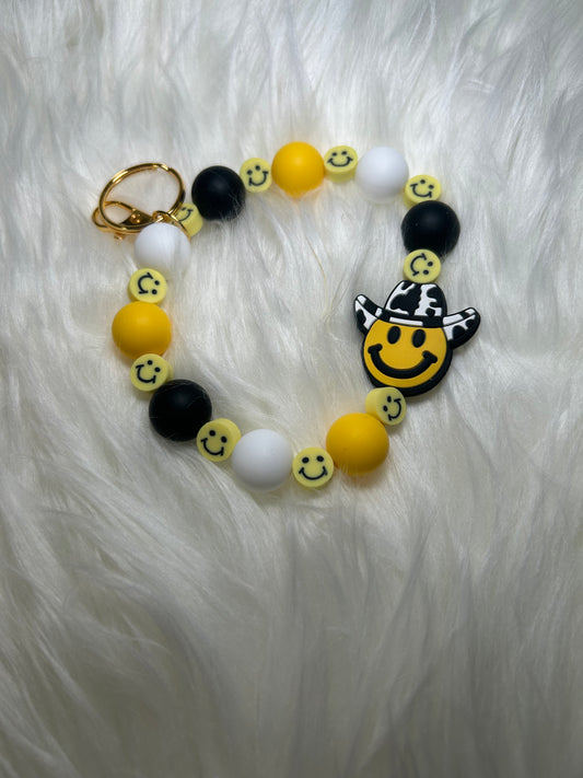 Yellow, black, and white smiley face Wristlet Keychain