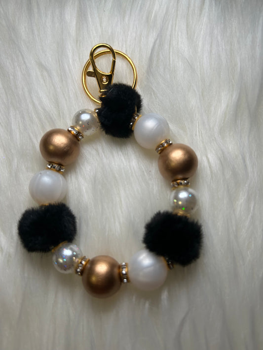 White, black, and gold wristlet keychain